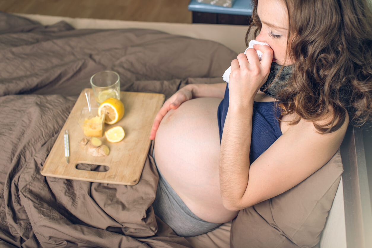 mujer embarazada enferma gripa termometro panuelo te jengibre limon cama