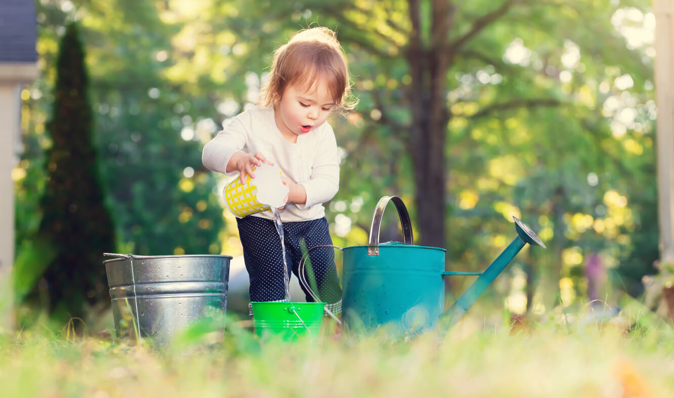 Une jeune fille qui transvase des seaux d'eau.