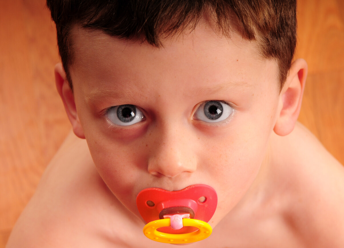 Un enfant avec une tétine dans la bouche.