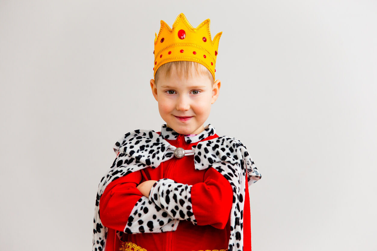 A young boy dressed up as a king.