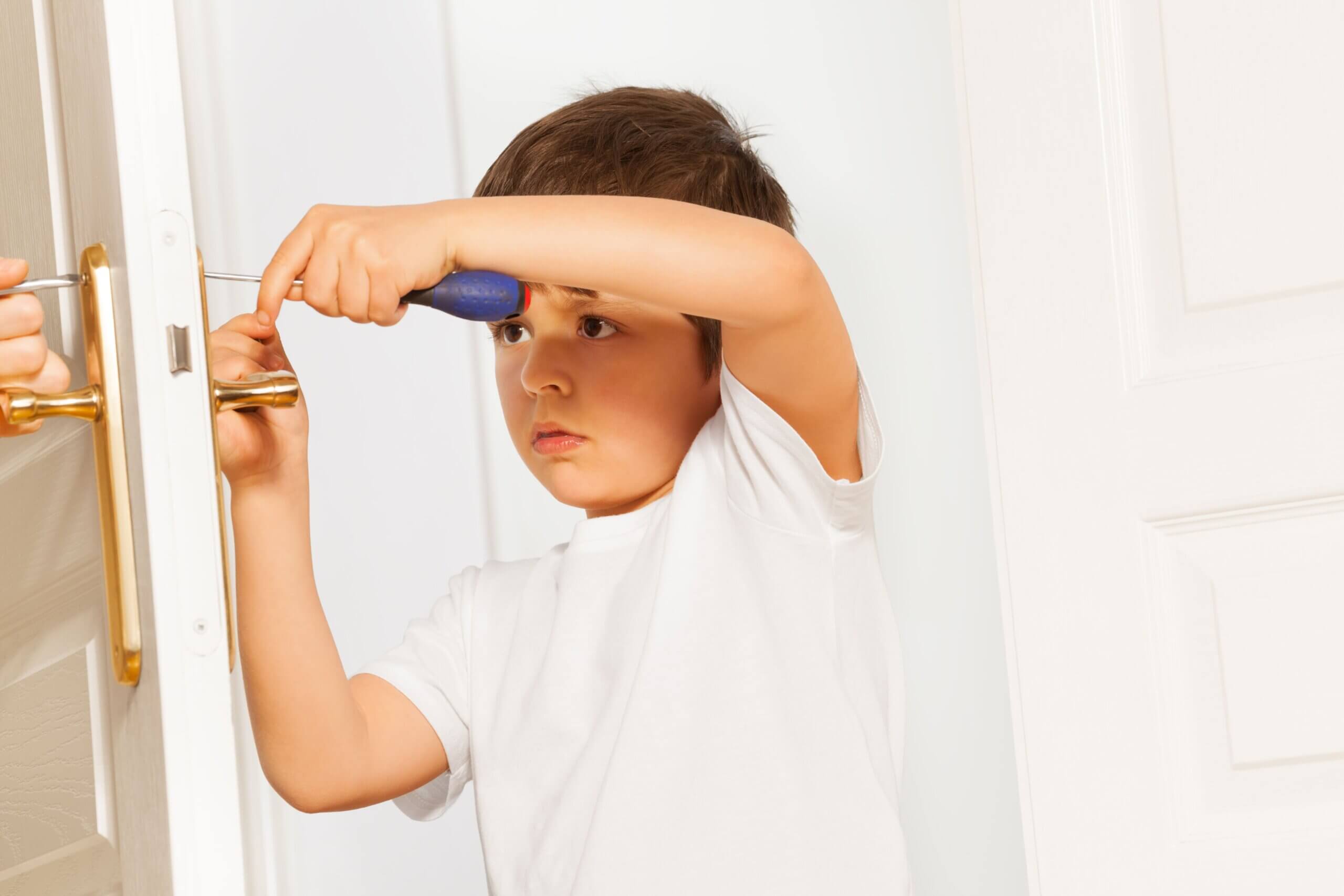 petit garçon réparant la porte