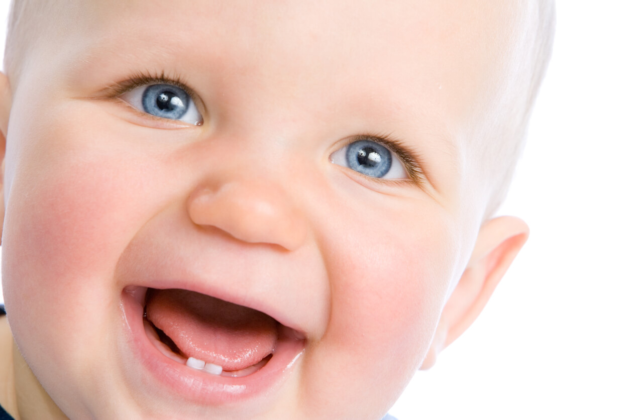 sonrisa de bebe feliz con dos dientes incisivos inferiores erupcionados