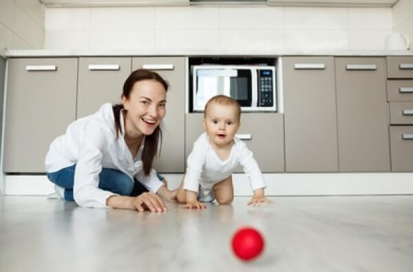 Une maman qui joue avec son bébé avec une balle.