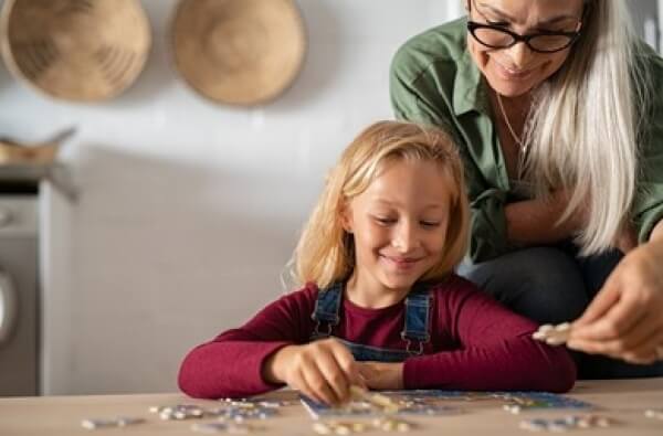 Une maman et sa fille qui font un puzzle.