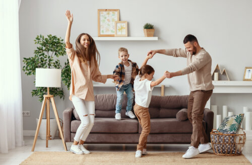 familia tipo feliz baila en la sala de la casa