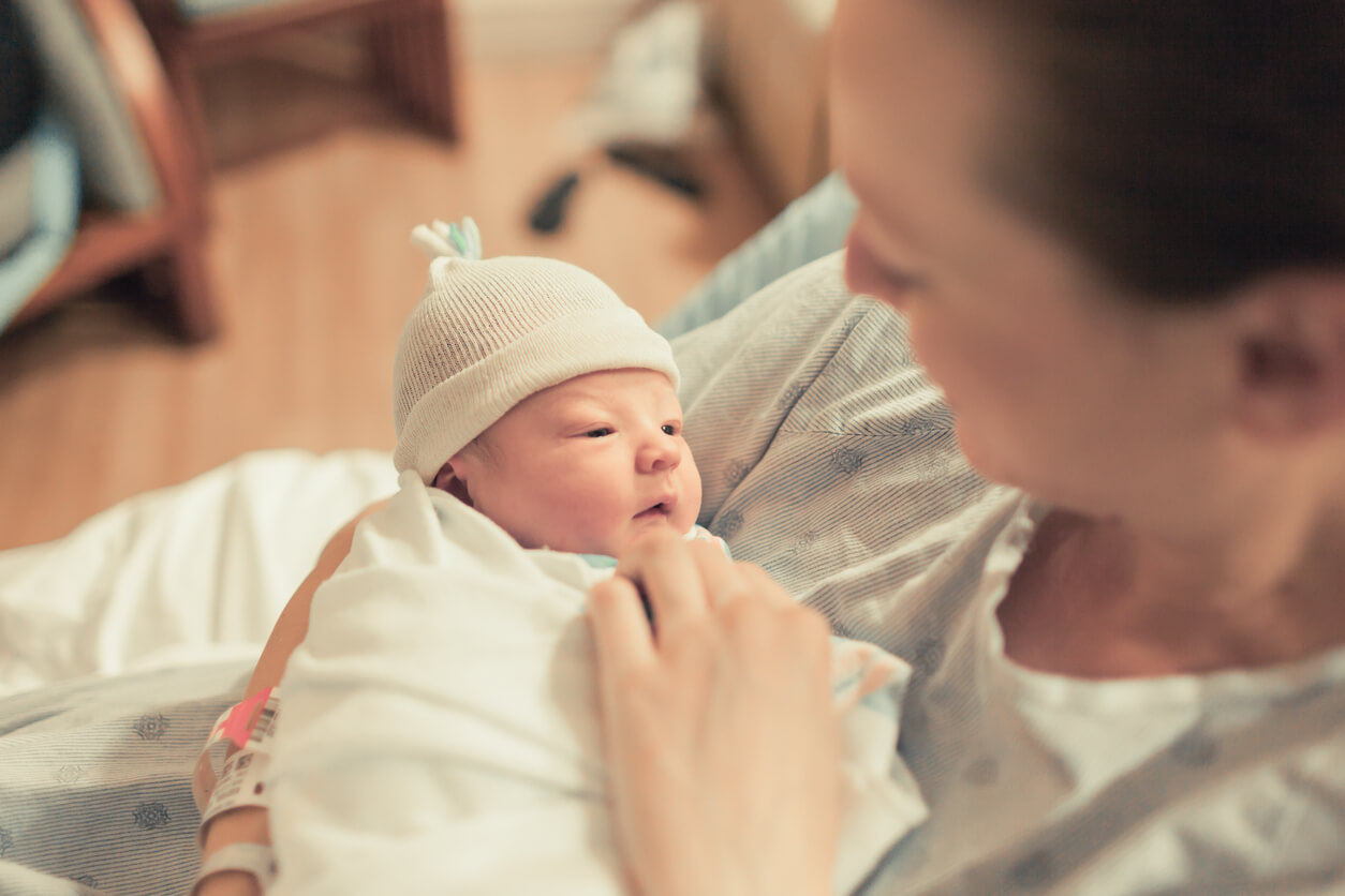 Une maman qui porte son nouveau-né dans ses bras.
