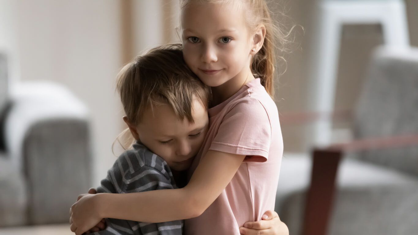concepto de empatia en la infancia nina abraza a su hermano menor y lo consuela