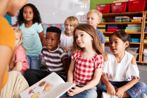 ninos de la escuela infantil escuchan atentamente al cuento que relata la maestra respeto diversidad igualdad valores