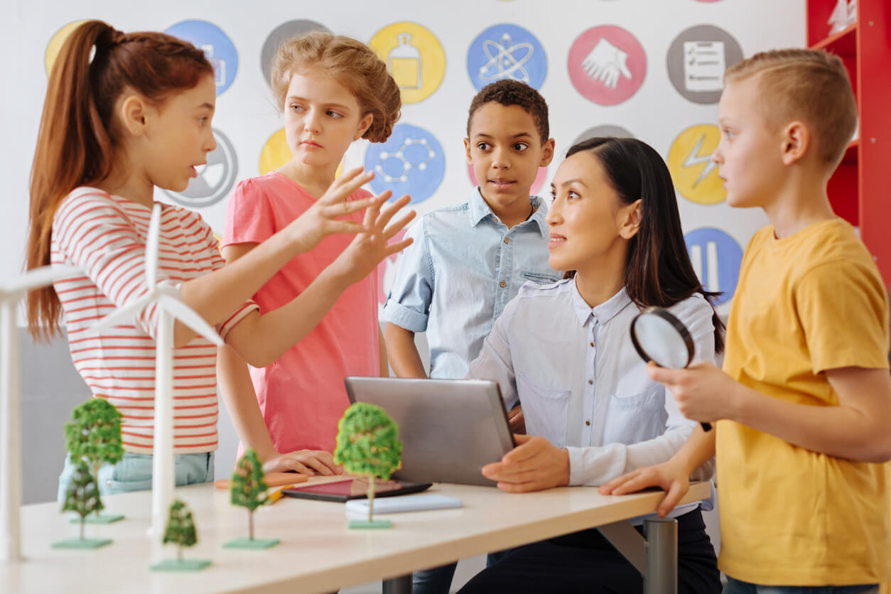 ninos exponen leccion proyecto de ciencias invesigacion al docente a cargo maestra profesora metodo de ensenanza aprendizaje colaborativo trabajo en grupo