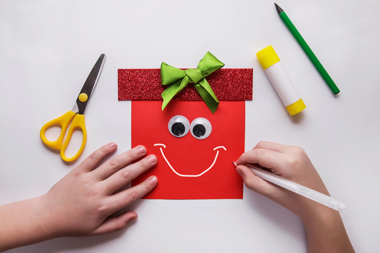 mains d'enfant sur un cadeau de noël rouge