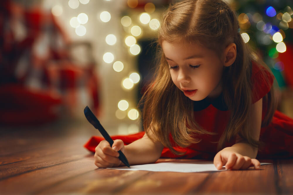 Niña escribiendo su carta de Navidad