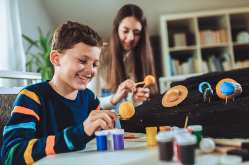 madre e hijo preparan proyecto de ciencias sistema solar