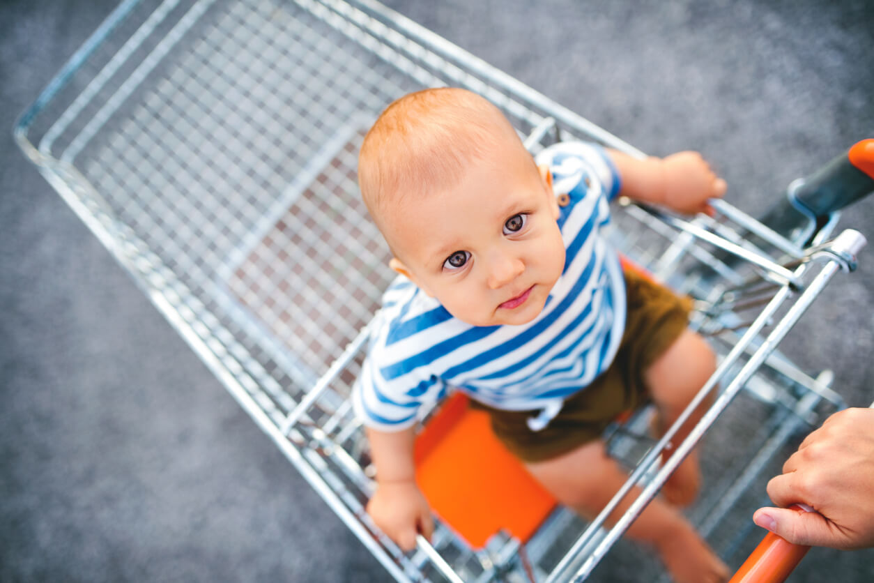 A baby in a shopping cart.