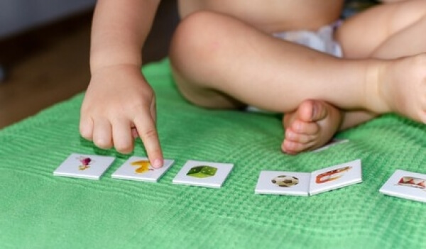 Un jeune enfant qui joue avec des cartes.