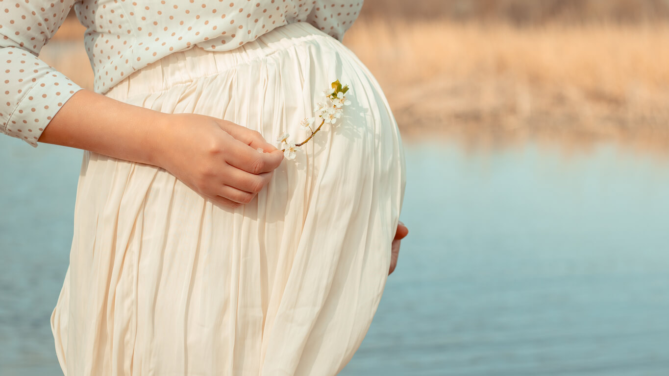 Une femme enceinte au bord de l'eau.