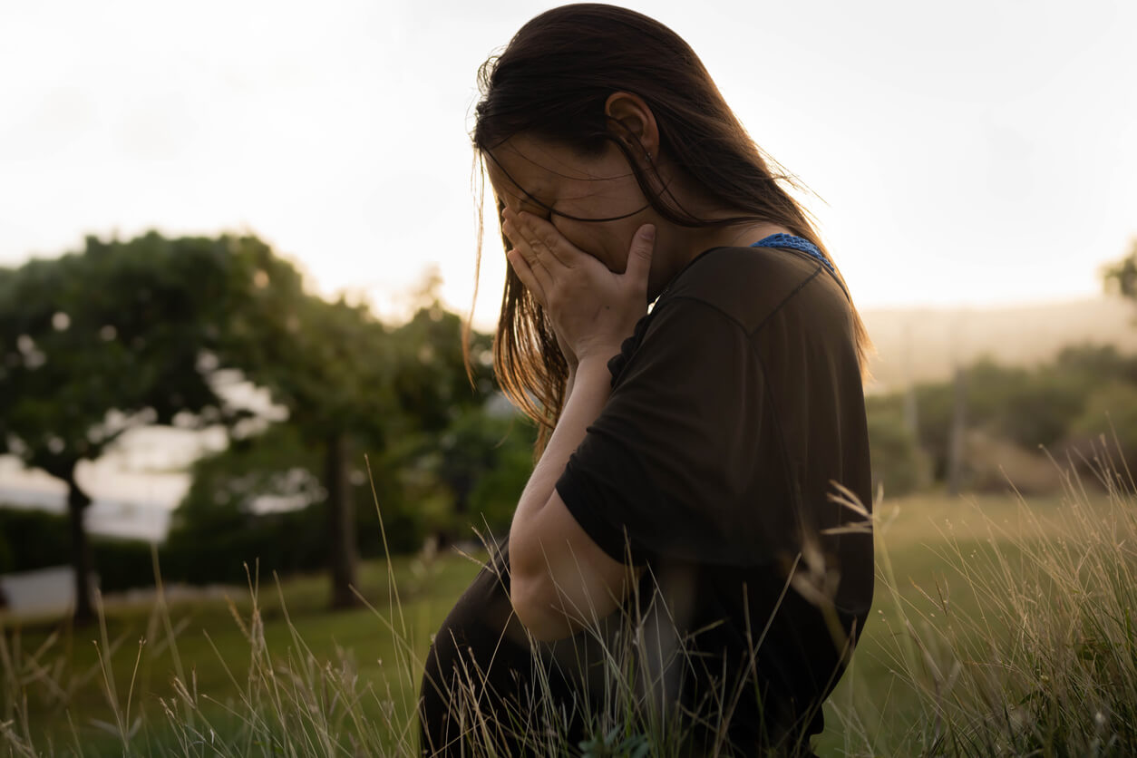 Une femme enceinte triste dans un champ.