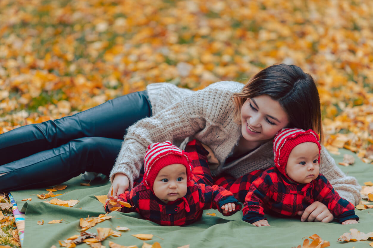 madre e hijos tummy time tiempo boca abajo en el parque manta hojas otono