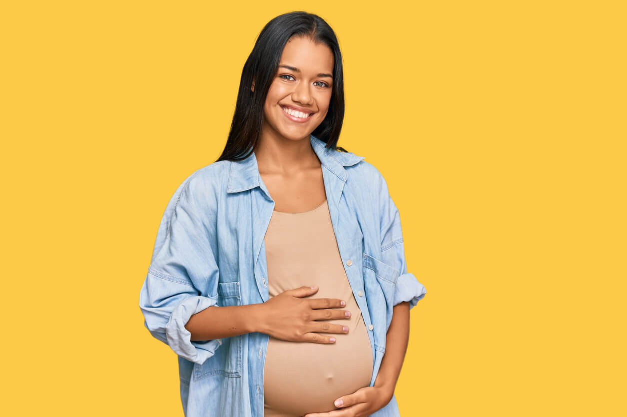 Une femme enceinte qui sourit.