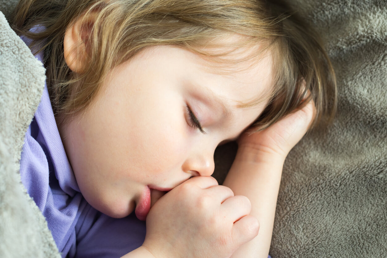 Un enfant qui dort le pouce dans la bouche