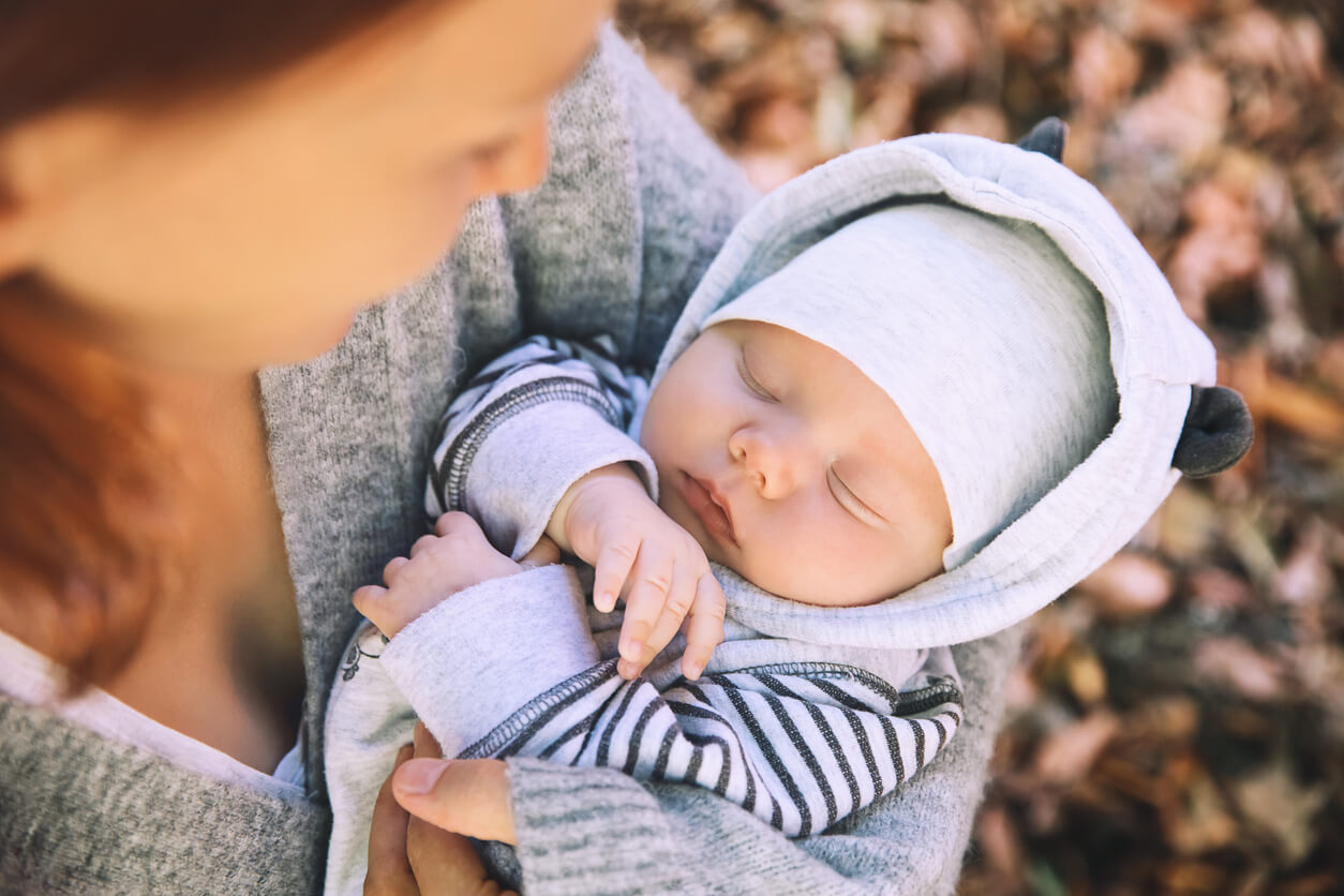 nouveau-né dans les bras de sa mère en automne