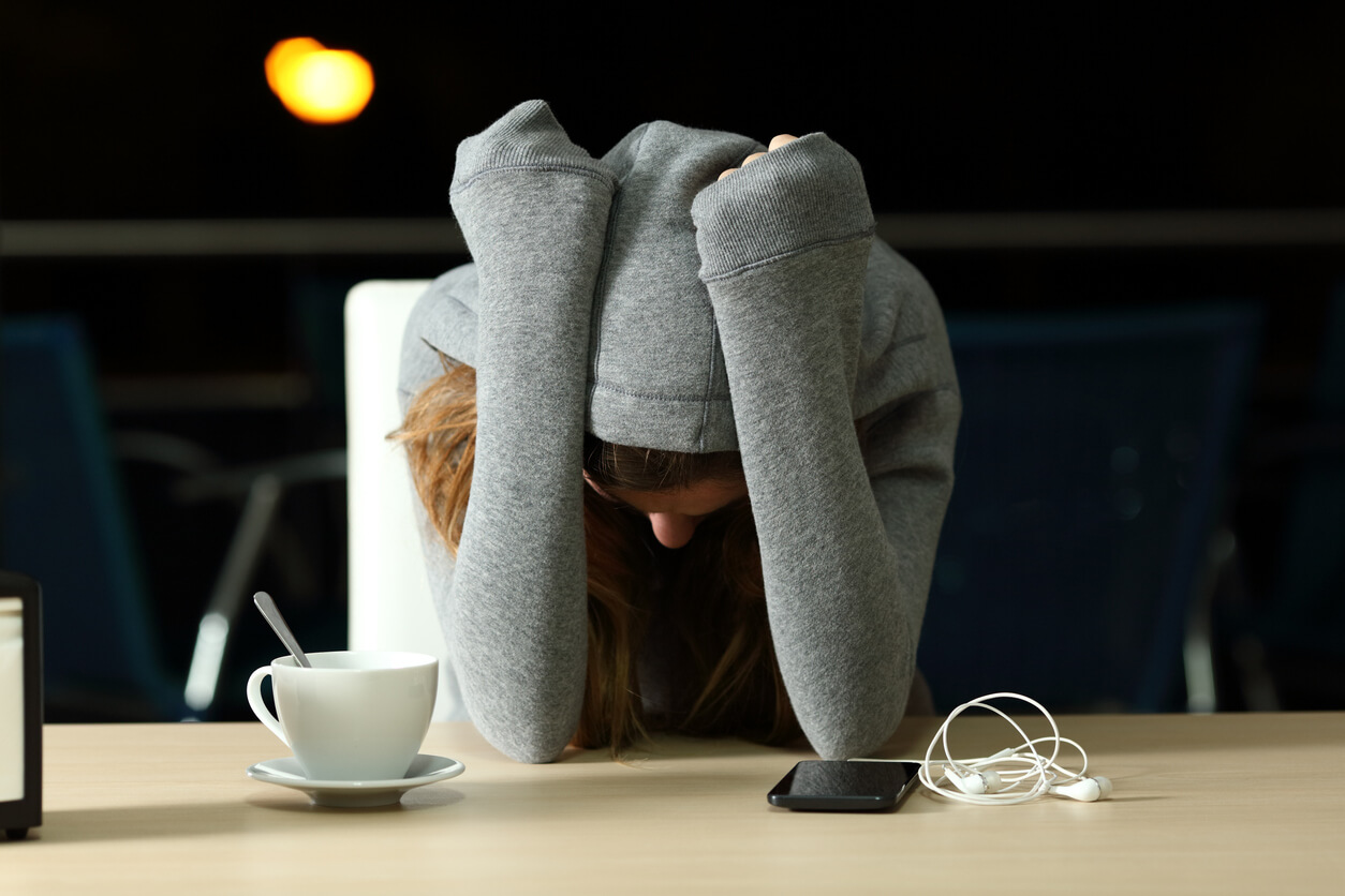 En tonåring på ett kafé ser trött ut.