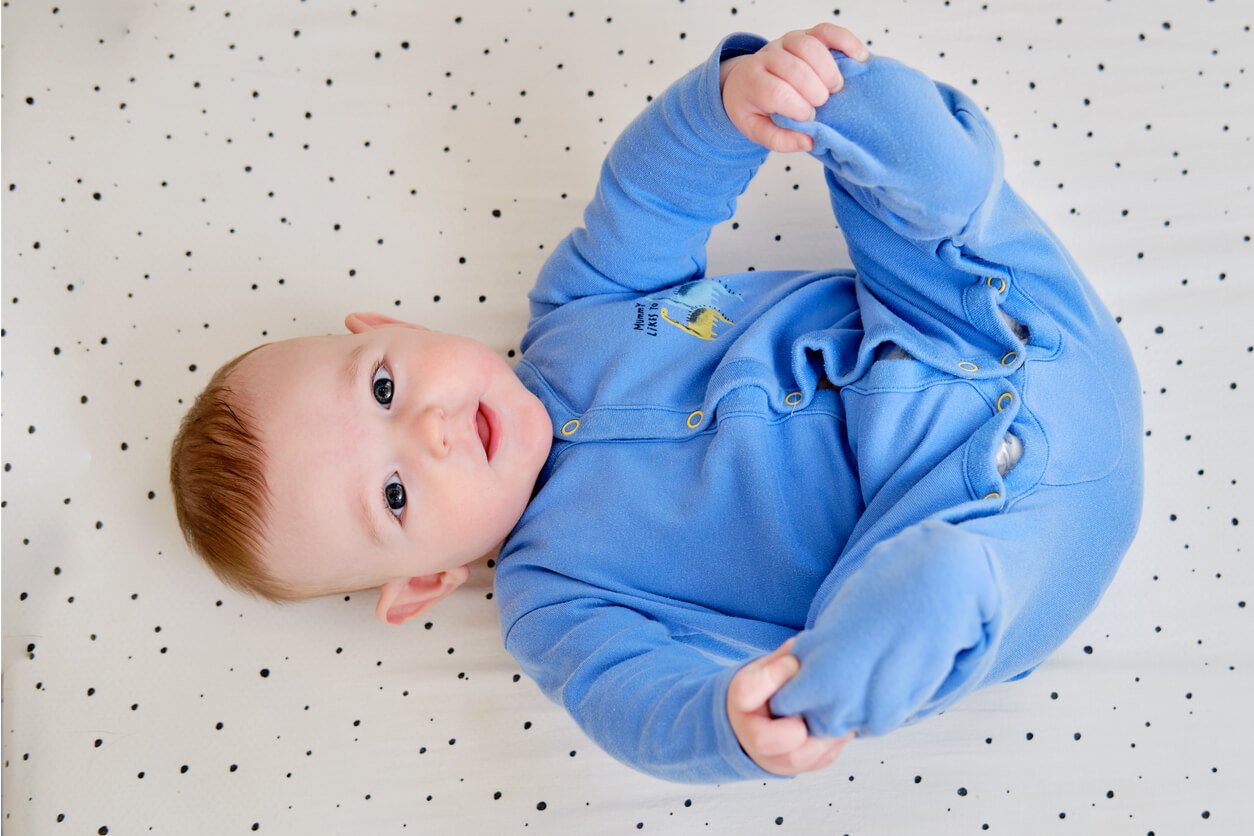 En bebis klädd i blå bomullspyjamas.