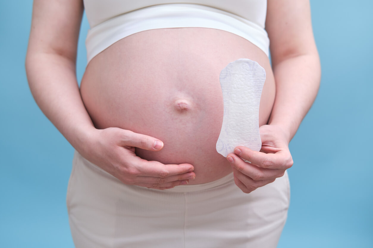 En gravid kvinne holder et truseinnlegg.