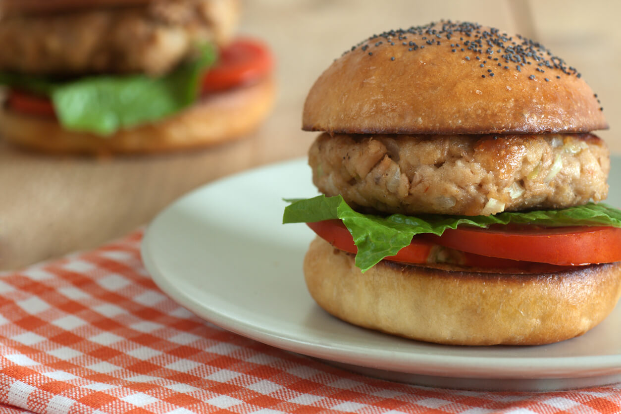 hamburguesa de atun en conserva pan lechuga tomate plato mantel cuadrille