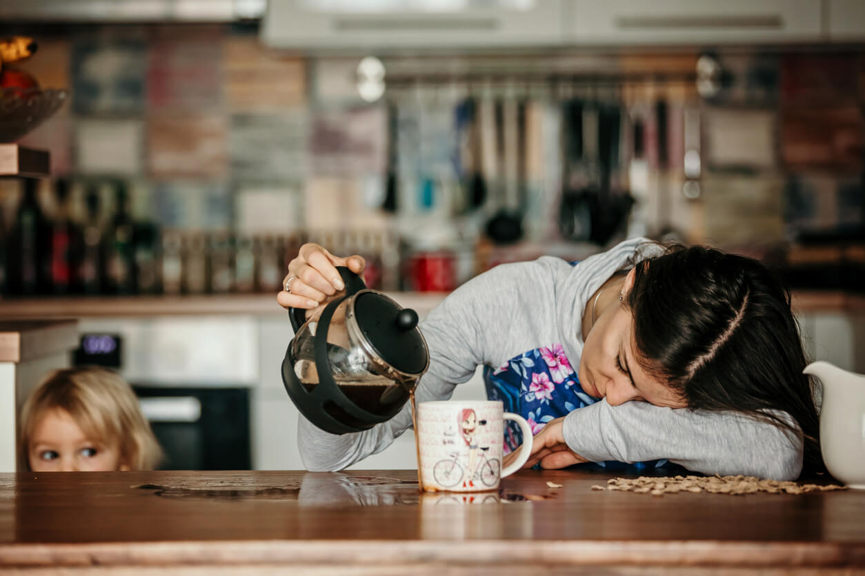 une mère endormie épuisée fatiguée s'endort en versant du café dans une tasse et se renverse sur la table