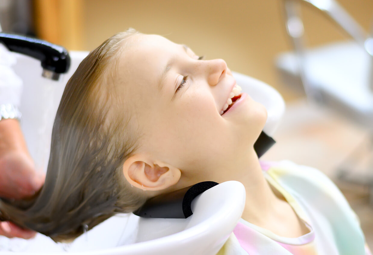 fille se lave les cheveux chez le coiffeur