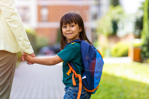 nina va a la escuela infantil de la mano