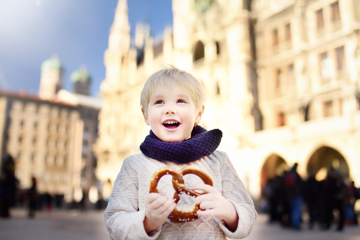 nino aleman con pretzel en mano edificio ayuntamiento en Munich Alemania