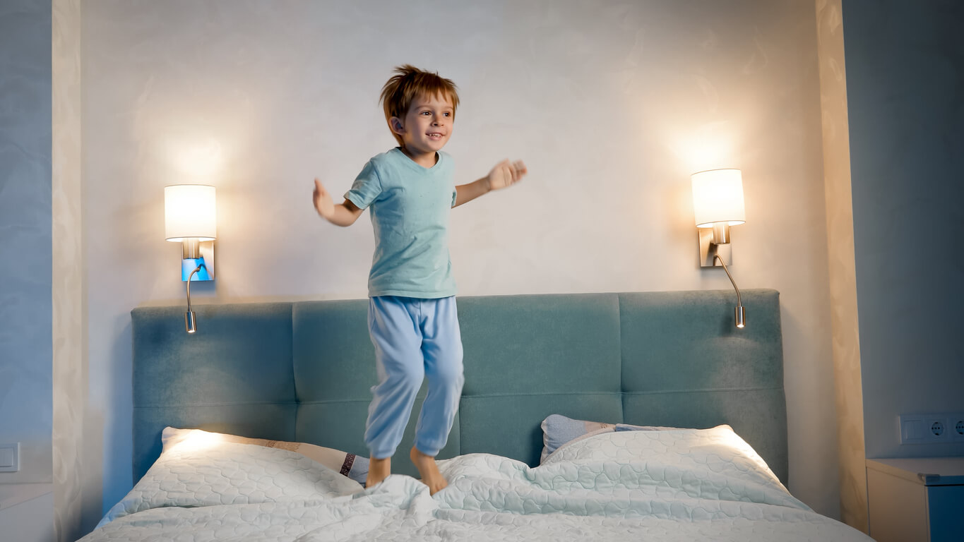 garçon saute dans le lit de ses parents la nuit, il ne veut pas dormir