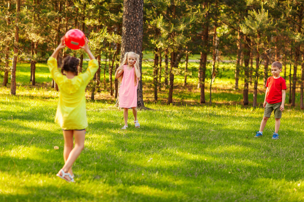 Des enfants qui jouent avec un ballon dans un parc.