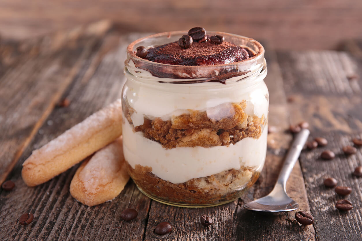 postre con huevo crudo tiramisu cafe chocolate crema vainillas frasco vidrio fondo madera