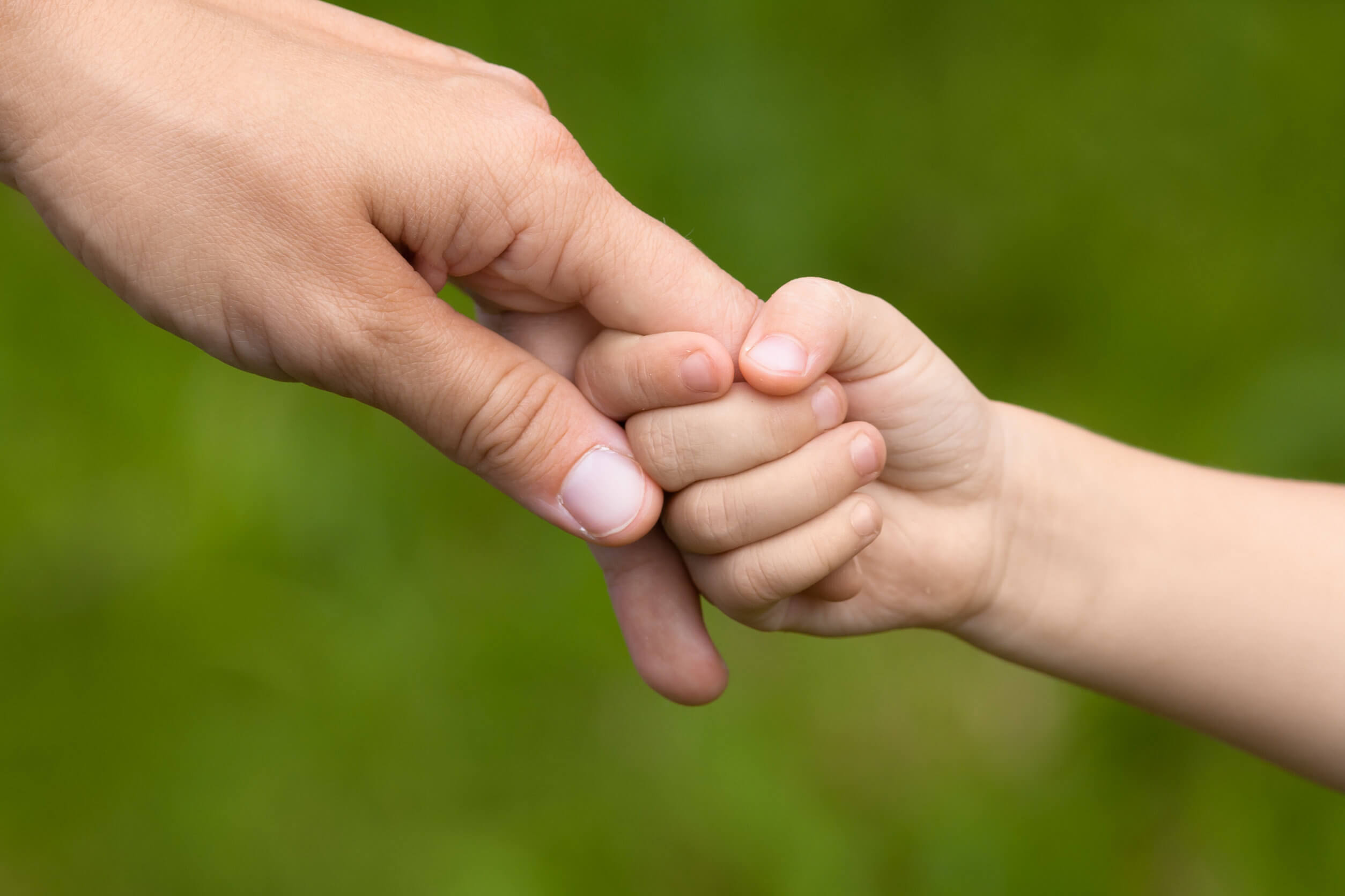 Hijo sosteniendo la mano de su madre.