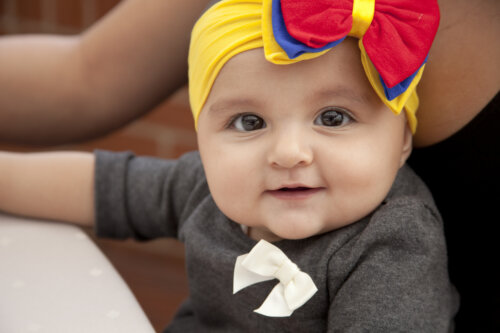 bebe mira a la camara accesorio pelo con colores de colombia rojo amarillo azul