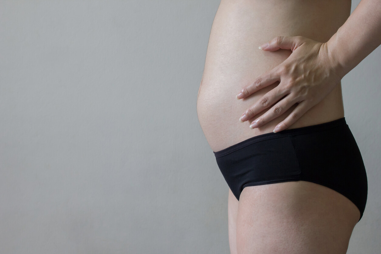 Le ventre légèrement arrondi d'une femme enceinte.