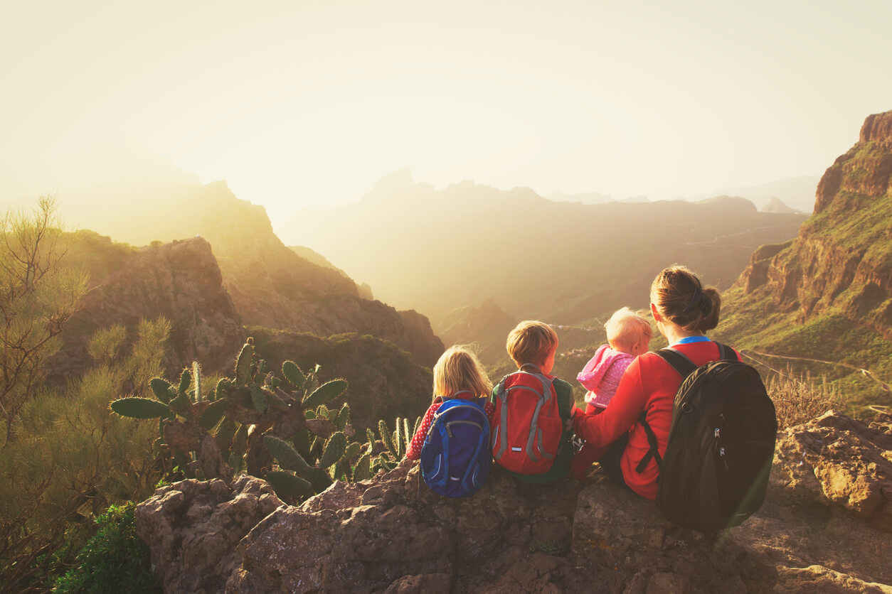 família sentada em uma pedra no topo das ilhas canárias do vale da montanha