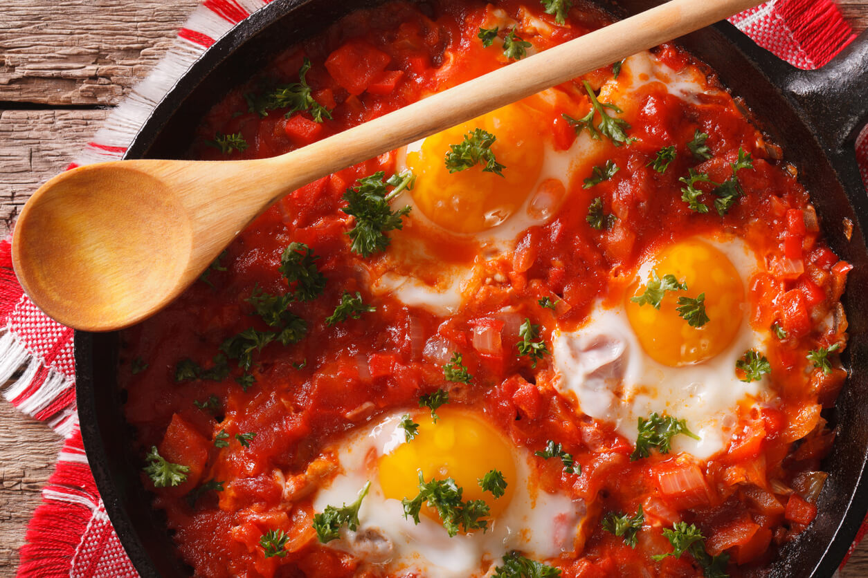 A skillet of eggs and tomato sauce.
