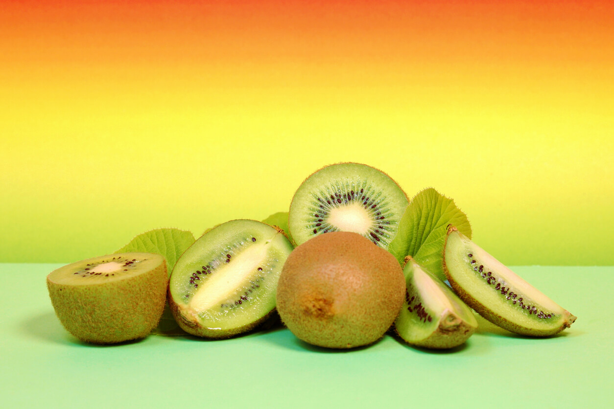 Hela och skurna kiwifrukter.