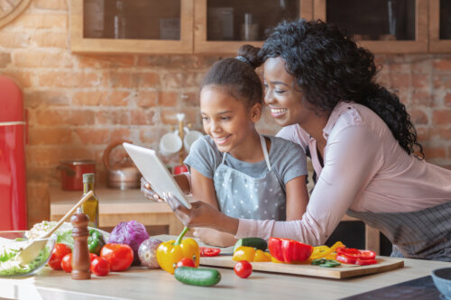 madre e hija elaboran receta con vegetales tableta