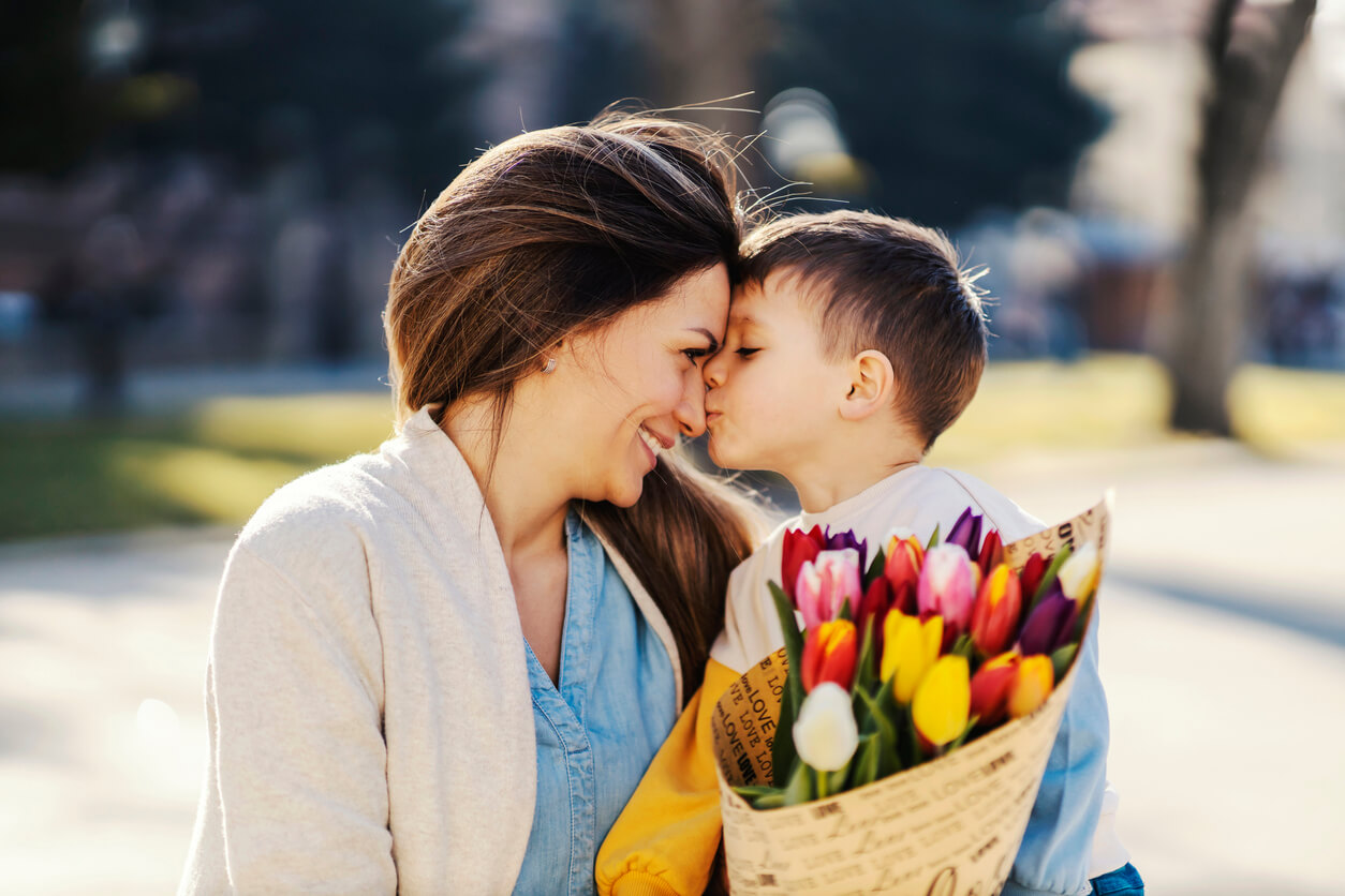 hijo besa a su madre amor dia de la madre flores gestos