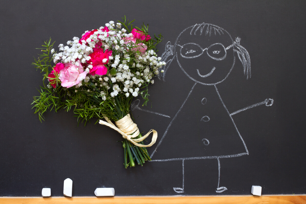 A drawing of a teacher on a blackboard with bouquet of flowers