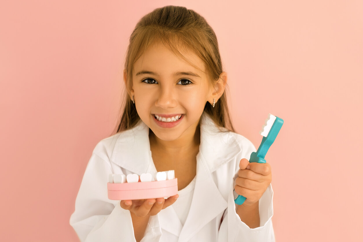 girl plays dentist mouth teeth brush overall
