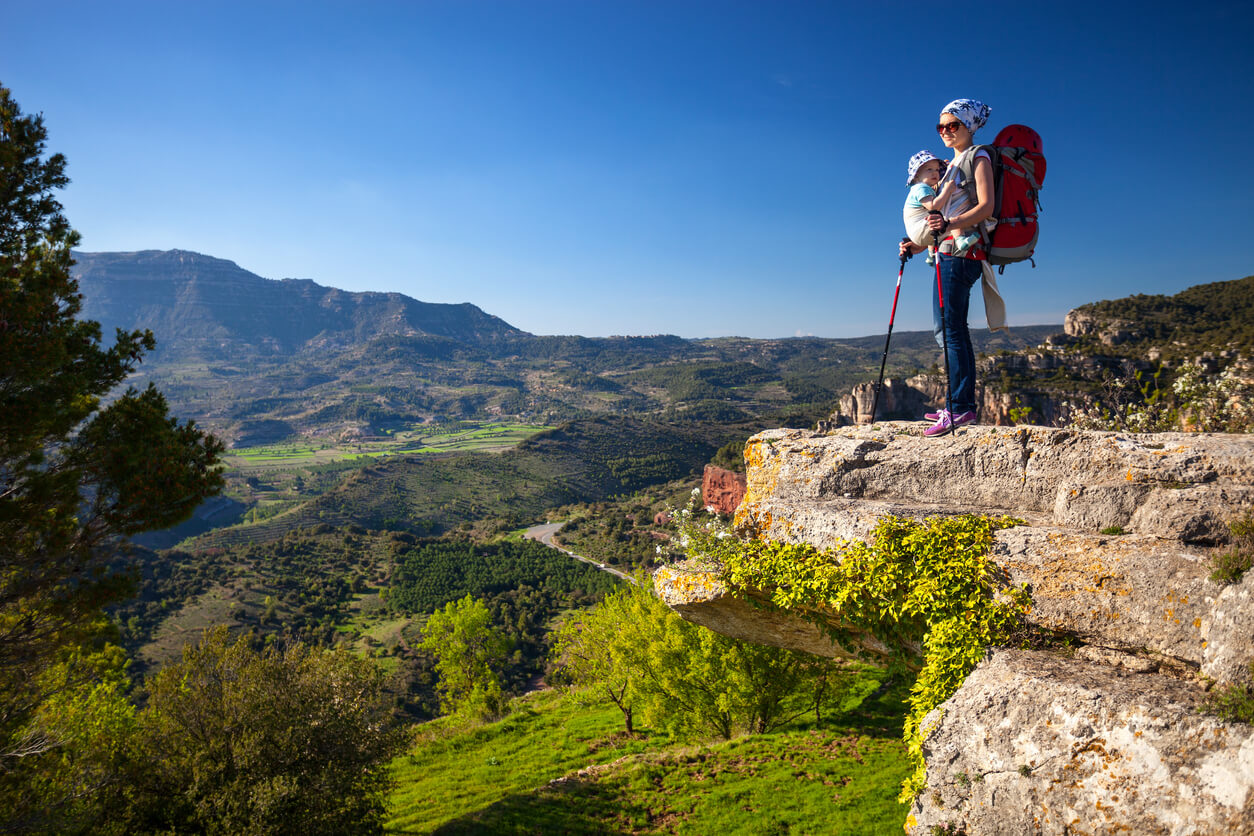 mujer bebe mochila portabebes en la montana haciendo senderismo