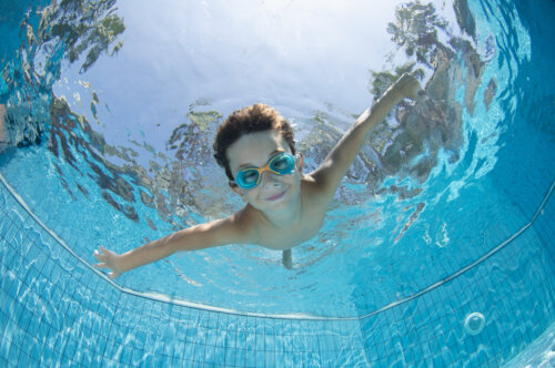 nino se sumerge en piscina de natacion