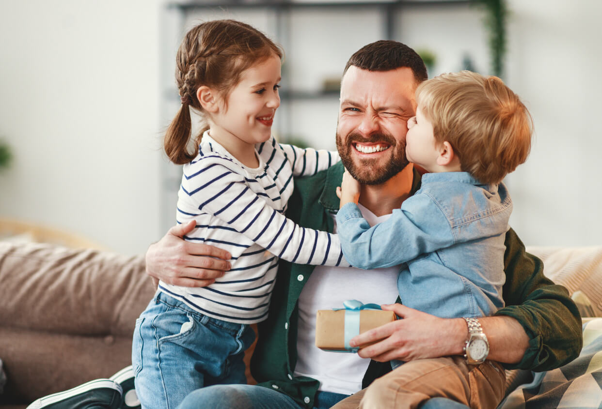 A son and daughter hugging their dad.