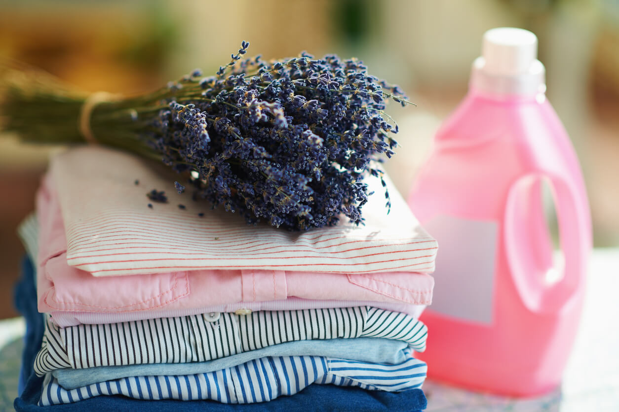 A bouquet of dry lavender on top of a pile of folded laundry.