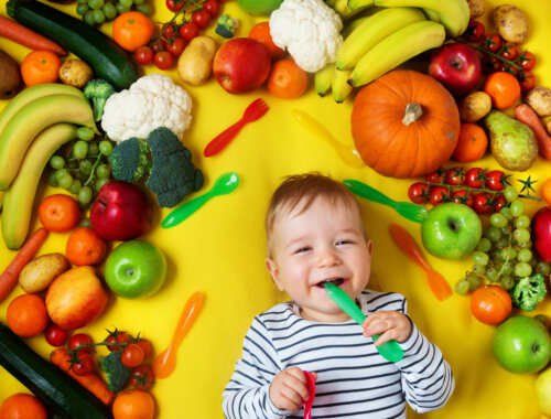 bebe acostado con frutas y verduras cuchara en la boca concepto de alimentacion saludable